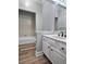 Clean bathroom with white vanity, tub, and wood-look flooring at 295 Creekview Trl, Fayetteville, GA 30214