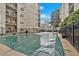 Outdoor pool area with a pool covered by a green tarp, surrounded by apartment buildings at 1075 Peachtree Ne Walk # A421, Atlanta, GA 30309