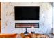 Modern living room with a sleek fireplace and large television mounted on a marble-tiled wall at 2505 Astaire Nw Ct, Atlanta, GA 30318