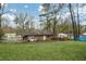 Spacious backyard featuring a brick home, lush lawn, mature trees, and an outdoor patio area with a covered area at 4488 Richard Rd, Conley, GA 30288