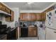 Kitchen featuring oak cabinets, black appliances, black and white backsplash, and tile floors at 4488 Richard Rd, Conley, GA 30288