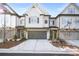 Two-story townhome with gray siding, stone accents, and a two-car garage at 613 Stone Field Nw Run, Marietta, GA 30060