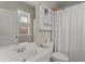 Clean bathroom with white vanity, shower/tub combo and linen cabinet at 4562 Worthings Dr, Powder Springs, GA 30127