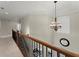 Spacious upstairs hall with wood railing and elegant chandelier at 4562 Worthings Dr, Powder Springs, GA 30127