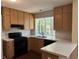 Kitchen with light wood cabinets, black appliances, and a window at 3763 Woodrose Ct, Snellville, GA 30039