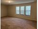 Spacious living room with neutral carpeting and three large windows at 3763 Woodrose Ct, Snellville, GA 30039