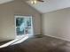 Large main bedroom with vaulted ceiling, carpet, and sliding glass door to deck at 3763 Woodrose Ct, Snellville, GA 30039