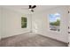 Bright bedroom with grey carpet, ceiling fan, and two large windows at 1732 Beecher Nw St, Atlanta, GA 30310