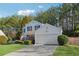 Two-story house with attached garage, American flag, and wooded backdrop at 5785 Stephens Mill Dr, Sugar Hill, GA 30518