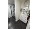 Modern bathroom featuring black hexagon tile floor, glass shower, and white vanity with an ornate mirror at 1765 Rubye Lee Ln, Dacula, GA 30019