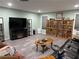 Comfortable living room features a black leather couch, wood bookcases, and gray flooring at 1765 Rubye Lee Ln, Dacula, GA 30019