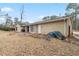 View of backyard showcasing lawn, siding on house, mature trees, and a bright, sunny sky at 1850 Cashmere Ct, Lithonia, GA 30058