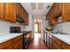 Galley kitchen with wood cabinets, white counters, black appliances, and skylight at 1850 Cashmere Ct, Lithonia, GA 30058