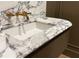 Elegant bathroom sink boasts a luxurious white marble countertop and chic brass fixtures at 2515 Habersham Nw Rd, Atlanta, GA 30305