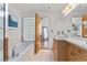 Bright bathroom featuring a soaking tub, vanity with sink, and glass block window at 3235 Roswell Ne Rd # 615, Atlanta, GA 30305