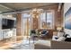 Sunlit living room highlights the exposed brick, tall windows, and chic decor at 3235 Roswell Ne Rd # 615, Atlanta, GA 30305