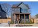 Two-story craftsman home with dark brick and teal siding, wood accents, and fenced yard at 1122 Nw Rice Nw St, Atlanta, GA 30318