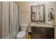 Clean bathroom with granite vanity, shower/tub combo, and striped shower curtain at 9994 Inisfree Dr, Johns Creek, GA 30022