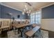 Formal dining room with a rustic wooden table, blue walls, and chandelier at 9994 Inisfree Dr, Johns Creek, GA 30022