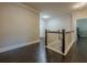 Upstairs hallway featuring hardwood floors and a modern railing at 9994 Inisfree Dr, Johns Creek, GA 30022