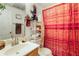 Functional bathroom with a sink, mirror, shelving and red-themed shower curtain at 1620 Cedar Hl, Douglasville, GA 30134