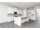 Modern kitchen with white cabinets, center island, and gray backsplash at 412 Newland Way, Acworth, GA 30102