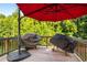 Back deck with red umbrella and two covered grills at 4568 Mantova Dr, Buford, GA 30519