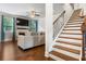 Living room with hardwood floors, fireplace, and large TV at 4568 Mantova Dr, Buford, GA 30519