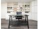 Home office in the basement with built-in shelving and a glass desk at 1495 Gabriel Dr, Lawrenceville, GA 30043