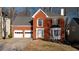 Brick house with two-car garage and landscaped lawn at 1495 Gabriel Dr, Lawrenceville, GA 30043