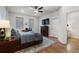 Comfortable bedroom featuring neutral walls, hardwood floors, ceiling fan, and large windows at 124 Everley Walk, Alpharetta, GA 30009