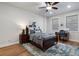 Bright bedroom featuring a ceiling fan, wood floors, two windows, and a bed with blue linens at 124 Everley Walk, Alpharetta, GA 30009