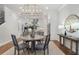 Elegant dining room features a round table with seating for four, and a large chandelier at 124 Everley Walk, Alpharetta, GA 30009