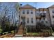 Inviting townhouse features a brick facade, multi-pane windows, and a charming entrance with elevated front yard at 124 Everley Walk, Alpharetta, GA 30009