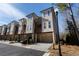 Beautiful townhome exterior with drive under garages, private balconies, and professionally landscaped yards at 124 Everley Walk, Alpharetta, GA 30009