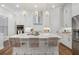 Bright, modern kitchen featuring a large island with pendant lighting, stainless steel appliances, and white cabinetry at 124 Everley Walk, Alpharetta, GA 30009