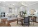 Open concept kitchen with white cabinets, stainless steel appliances, island with seating, and view to the dining area at 124 Everley Walk, Alpharetta, GA 30009