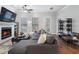 Cozy living room with fireplace, large TV, and comfortable gray sectional sofa. Hardwood floors throughout at 124 Everley Walk, Alpharetta, GA 30009