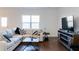 Spacious living room with hardwood floors and large TV at 5482 Fountainhead Ln, Auburn, GA 30011
