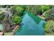 Picturesque aerial view of a serene lake surrounded by lush greenery and beautiful homes at 5915 Masters Club Dr, Suwanee, GA 30024
