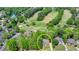 Aerial view of the property near a golf course and other houses, nestled among trees in a serene neighborhood setting at 5915 Masters Club Dr, Suwanee, GA 30024