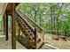 A wooden staircase leads to the upper deck with black railings, a tranquil natural setting at 5915 Masters Club Dr, Suwanee, GA 30024
