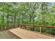 A wood deck with black railing overlooks the greenery at 5915 Masters Club Dr, Suwanee, GA 30024