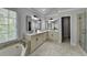Bathroom featuring double vanities, garden tub, walk-in shower with glass door, and a large window at 5915 Masters Club Dr, Suwanee, GA 30024