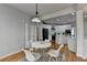 Bright dining area with a view of the kitchen, featuring hardwood floors and a modern pendant light at 5915 Masters Club Dr, Suwanee, GA 30024
