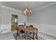 Charming dining room features modern chandelier, carpet, and wainscoting at 5915 Masters Club Dr, Suwanee, GA 30024