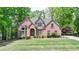 Lovely two-story brick home with mature trees, lush green lawn, and well-maintained landscaping at 5915 Masters Club Dr, Suwanee, GA 30024