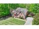 Aerial view of a two-story brick home surrounded by lush greenery with a well-manicured lawn and a concrete driveway at 5915 Masters Club Dr, Suwanee, GA 30024