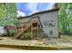 A two-story house with a wooden back deck and green lawn with lush trees around at 5915 Masters Club Dr, Suwanee, GA 30024