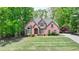 Beautiful two-story brick home featuring manicured lawn, mature trees, and a well-kept front yard at 5915 Masters Club Dr, Suwanee, GA 30024